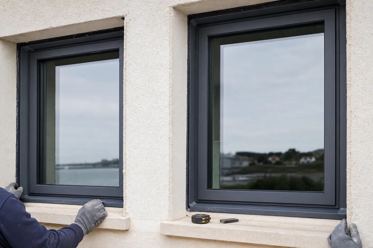 Façade vendéenne en enduit clair avec fenêtres aluminium posées en rénovation sous lumière marine